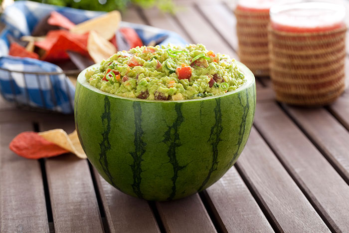 Firecracker guacamole served in a mini watermelon bowl