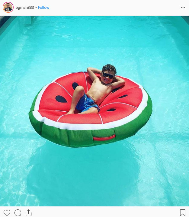 Child on a watermelon floaty in poll during summer