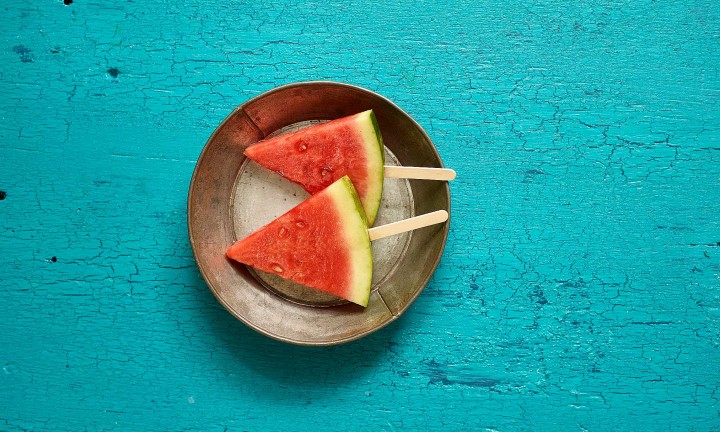 watermelon triangular cuts in metal pan on teal painted wooden background