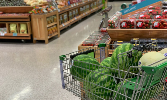 five whole watermelon in shopping cart in produce department of grocery store