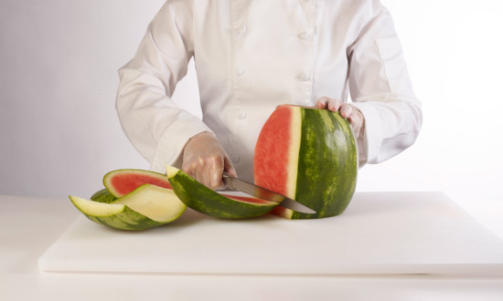 mini watermelon in process of being cut by chef