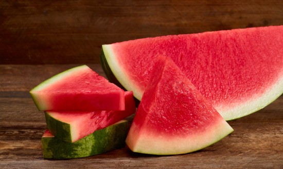 watermelon wedge and triangular cuts on wooden background