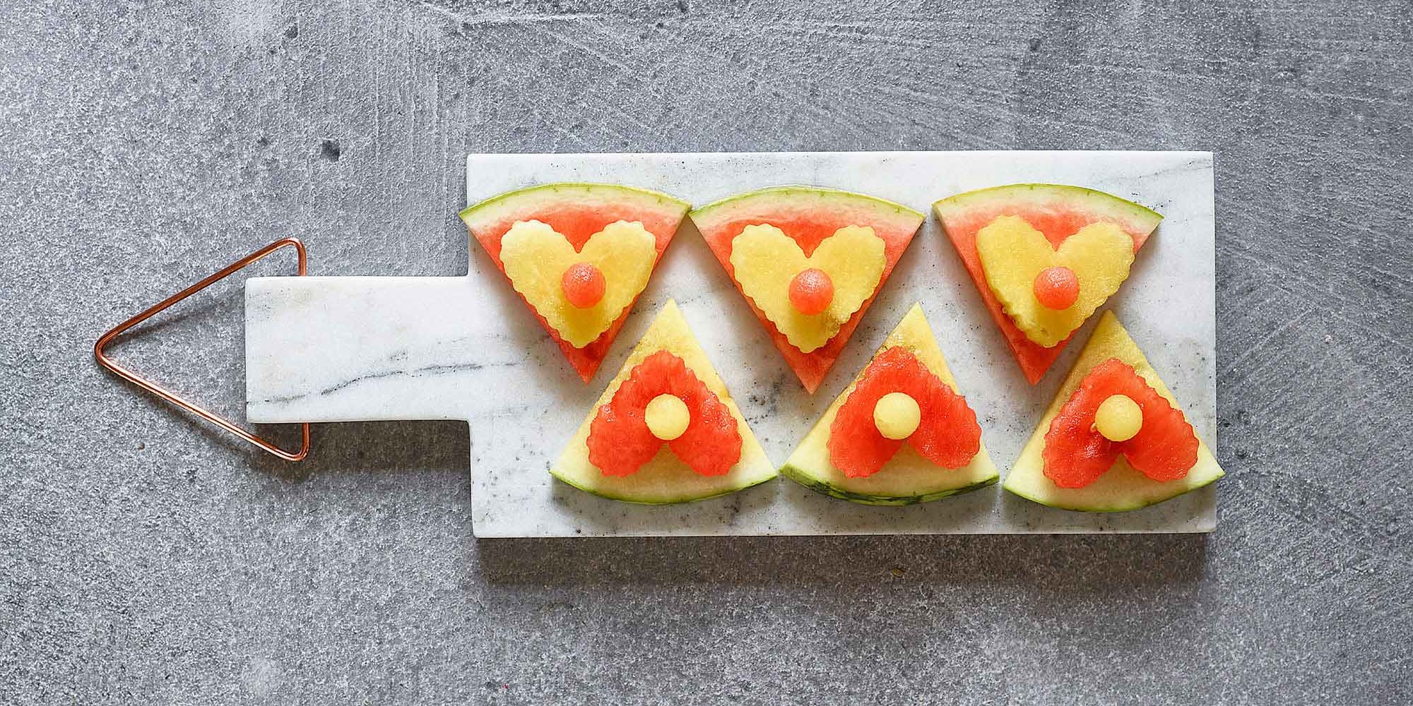 red and yellow triangular watermelon cut-out on marble cheese board