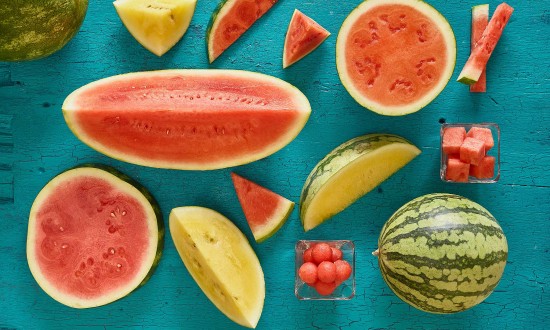 various watermelon cuts, including yellow on teal painted wooden background