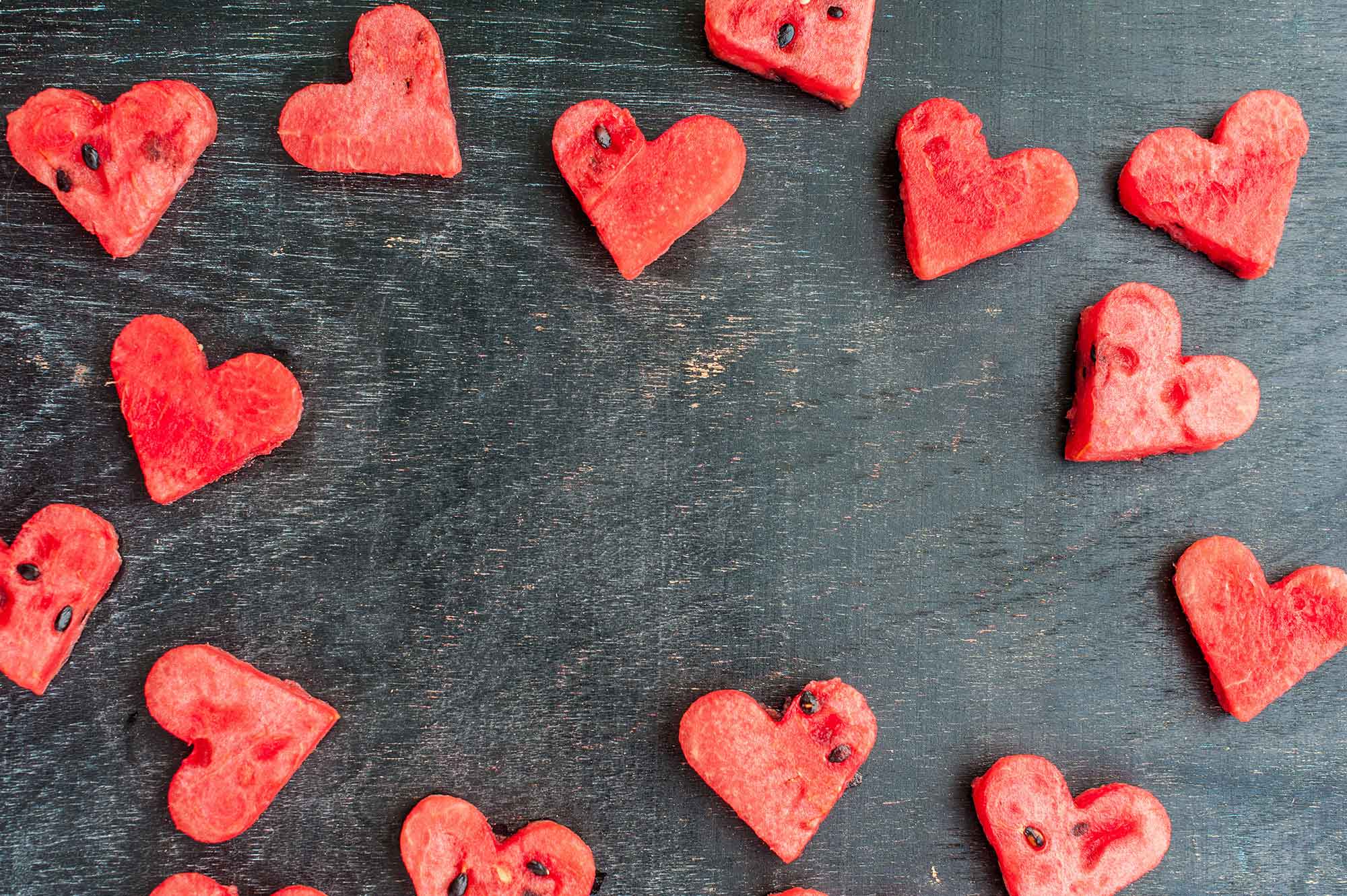 watermelon heart cutouts on black wooden table
