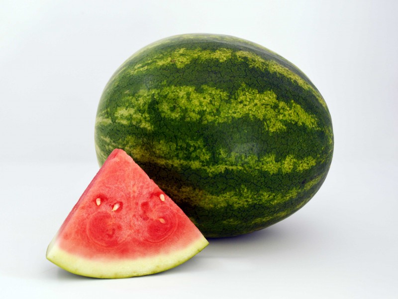 whole-mini watermelon with slice in foreground