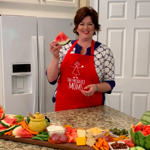 on-set screenshot with person in home kitchen with various watermelon and other produce