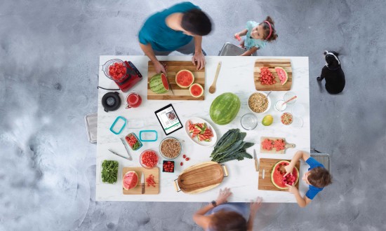 overhead view of watermelon prep, one man, one woman, two children (one boy, one girl) dog