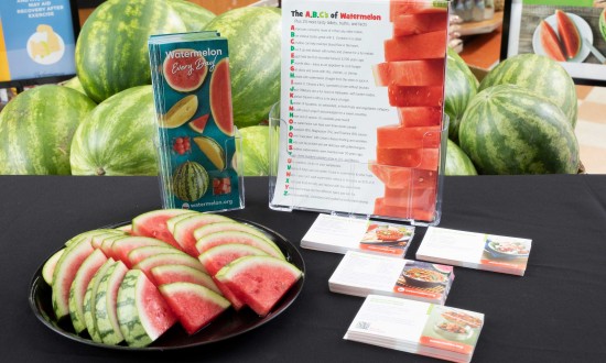 point of sale display with watermelon in background. Slices on black round tray. NWPB brochure, A-Z one-sheet and 4 varieties of recipe cards on table covered with black tablecloth