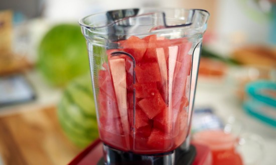 watermelon chunks in open blender. Mini watermelon (x2) in background