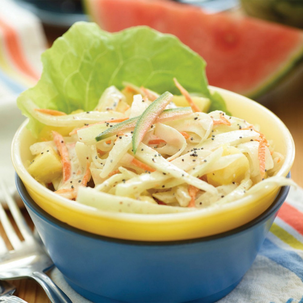 watermelon rind slaw in blue and yellow bowls (stacked) with forks on side. Watermelon wedge in background