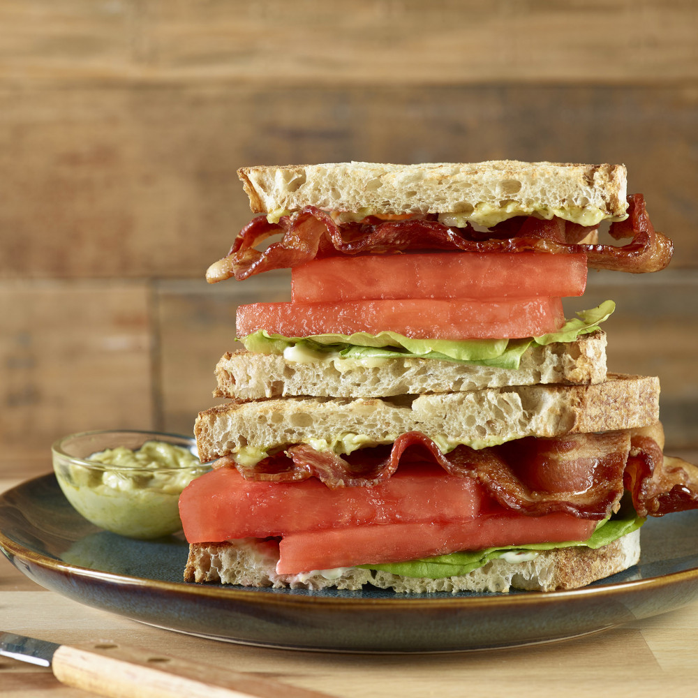 plated stacked sandwich atop wooden cutting board