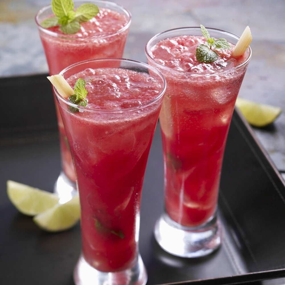 Three Watermelon Cherry Mojitos on serving tray, garnished with mint leaves and lime.