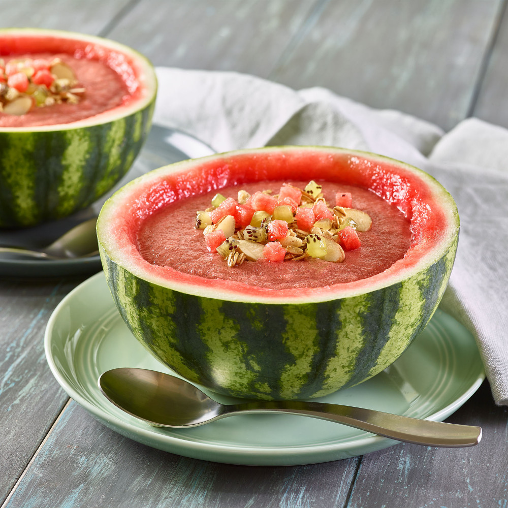 Two Watermelon Crunch Smoothie Bowls served in mini watermelon ½ round of rind. Garnished with watermelon, kiwi and slivered almonds.