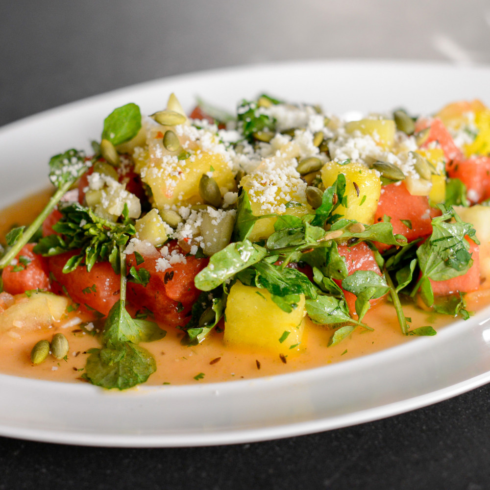 Watermelon Latin Salad served in white boat shaped dish.