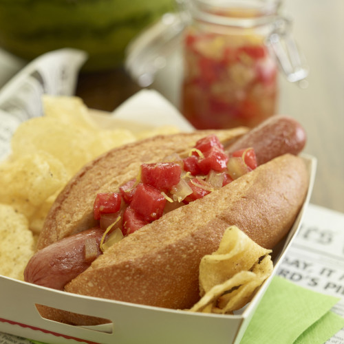 hot dog with relish with chips, relish jar in background