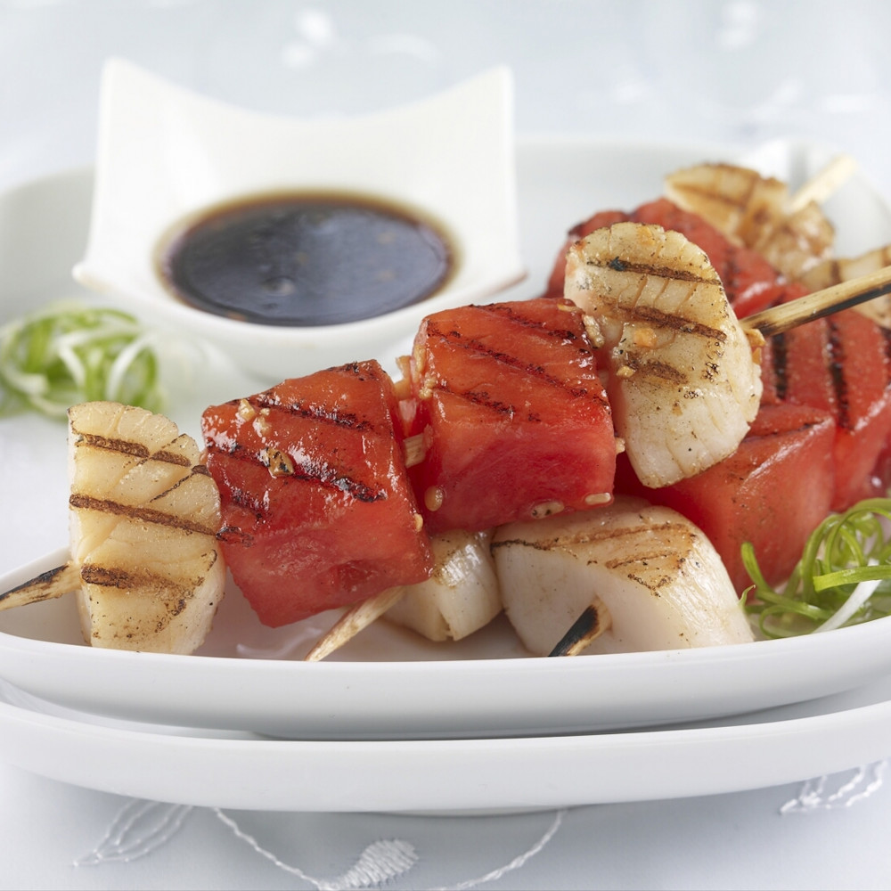 Grilled watermelon and scallop kebabs with dipping sauce.