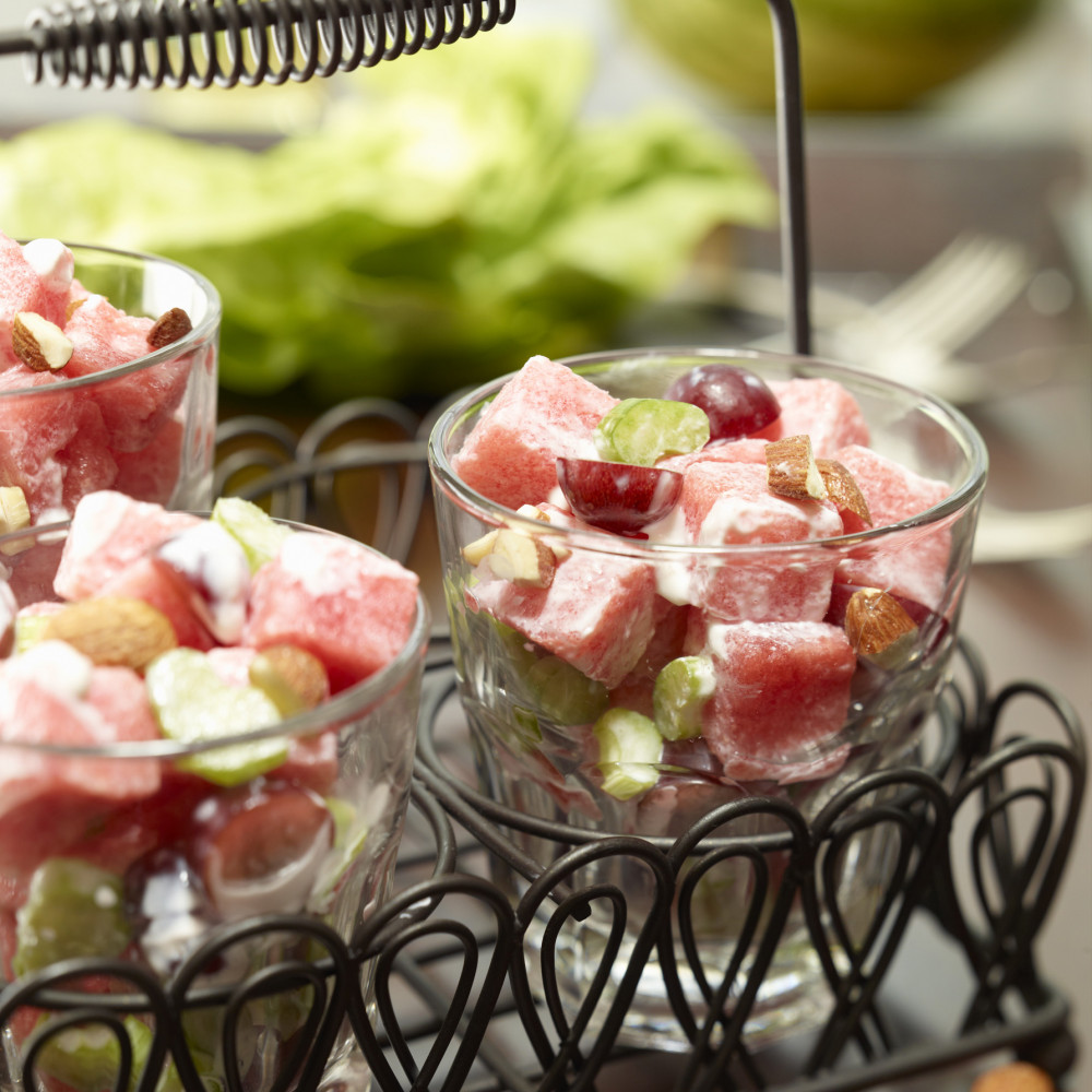 waldorf salad in 3 clear glasses in a carry-handled tray with almond garnish