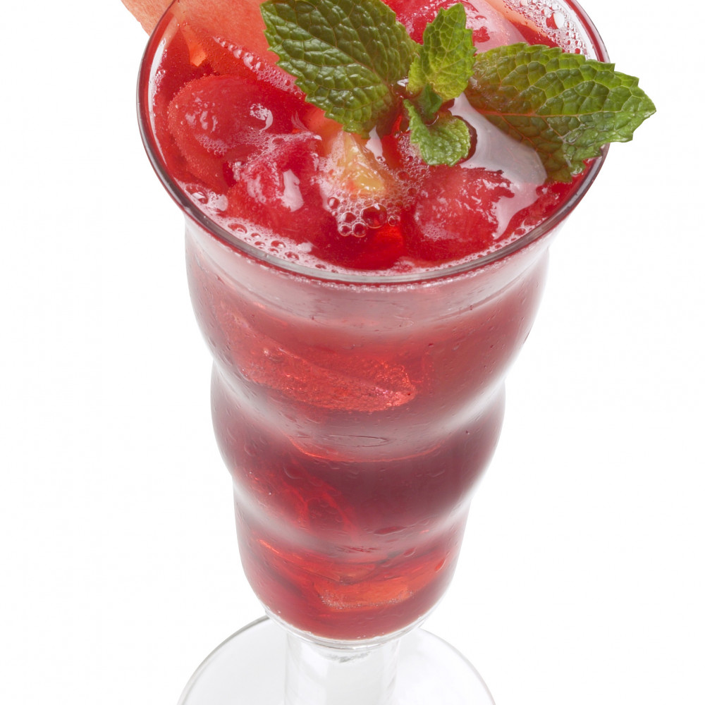 Watermelon Sangria served in clear pedestaled glass, garnished with mint leaves and triangular cut of watermelon.