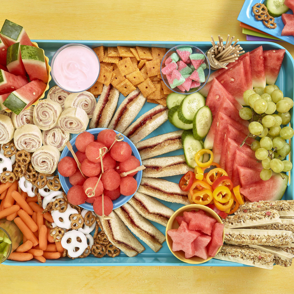 Kids grazing board overhead shot showing sandwiches, cracker, watermelon and other fruit