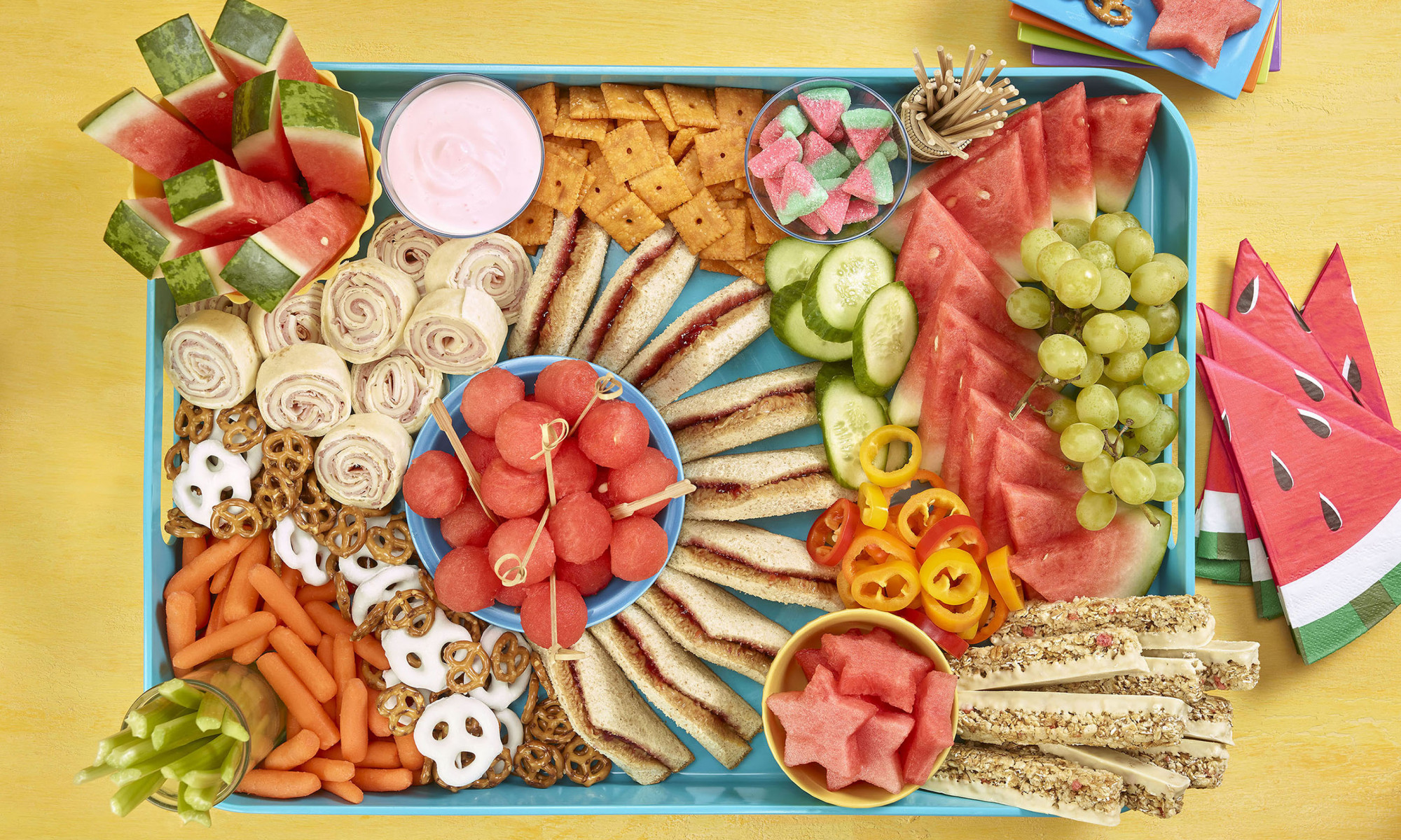 Kids grazing board overhead shot showing sandwiches, cracker, watermelon and other fruit