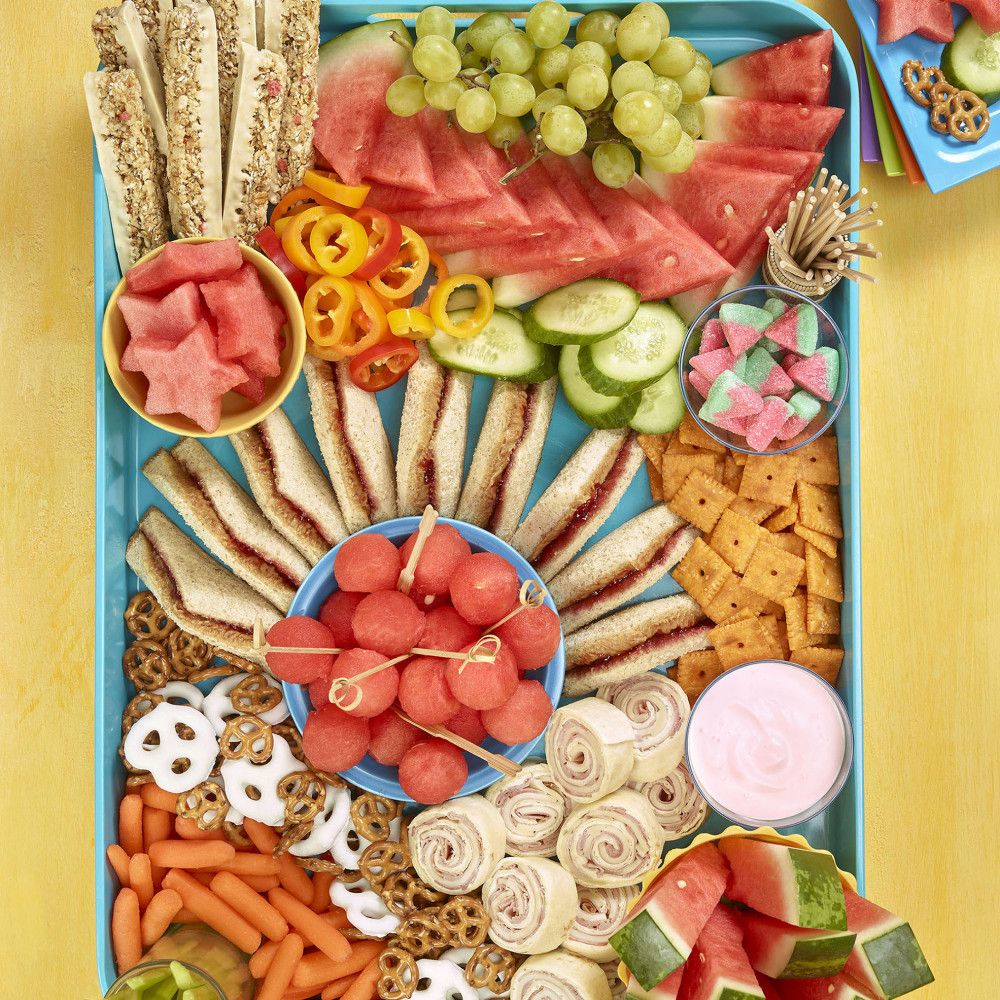 Kids grazing board overhead shot showing sandwiches, cracker, watermelon and other fruit