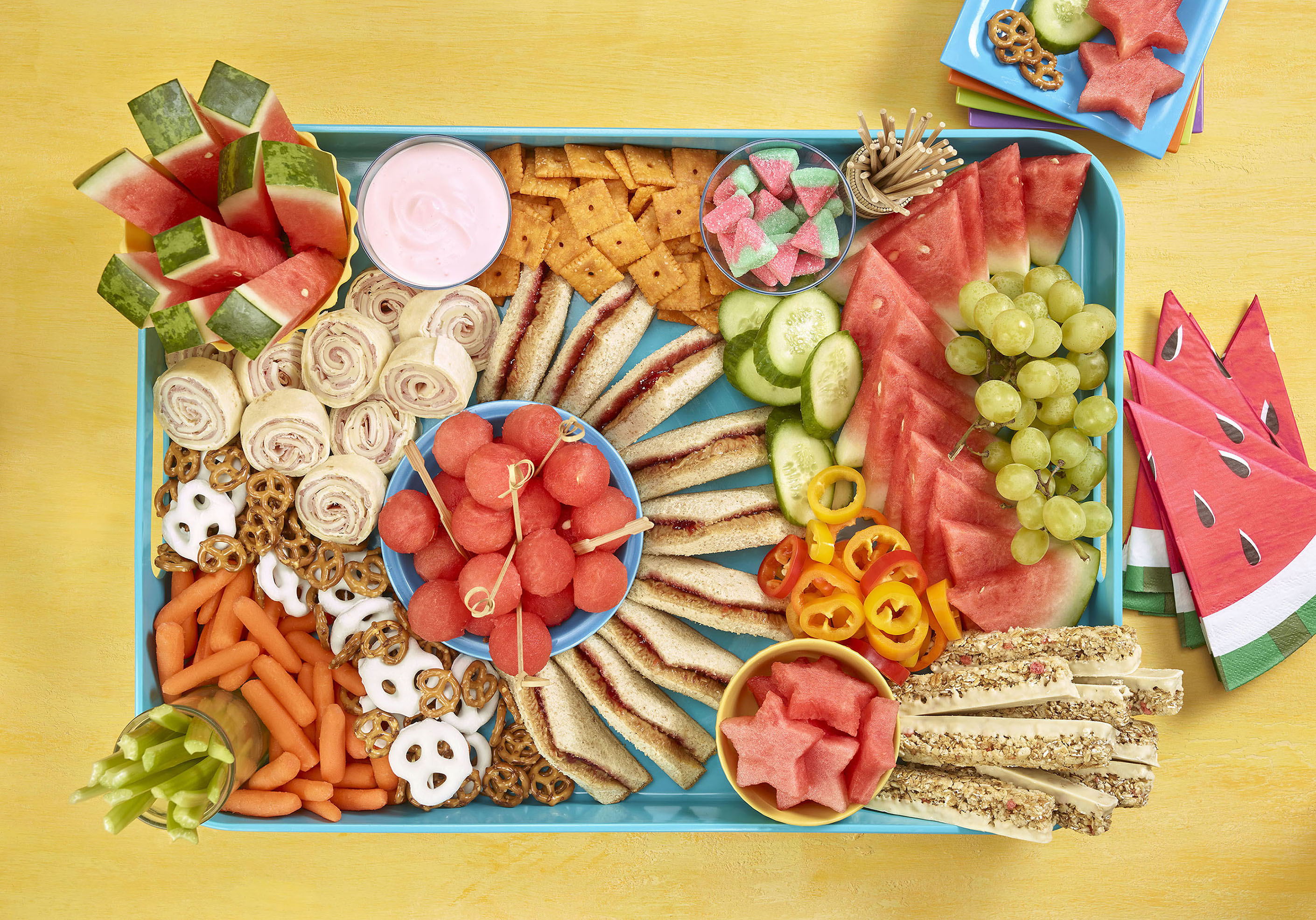 Kids grazing board overhead shot showing sandwiches, cracker, watermelon and other fruit