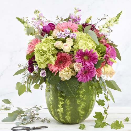 Floral centerpiece in a carved out watermelon on marble