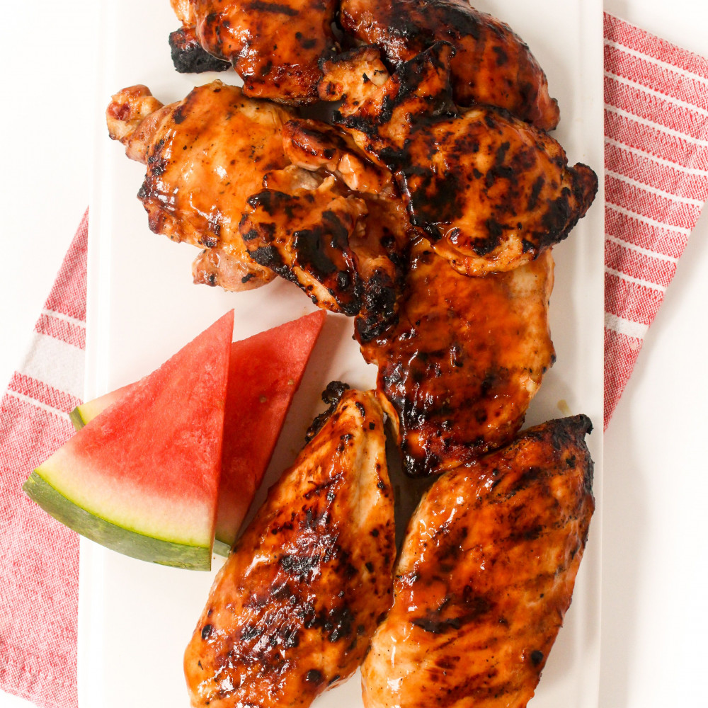 watermelon chicken on white plate with garnish of two watermelon wedges