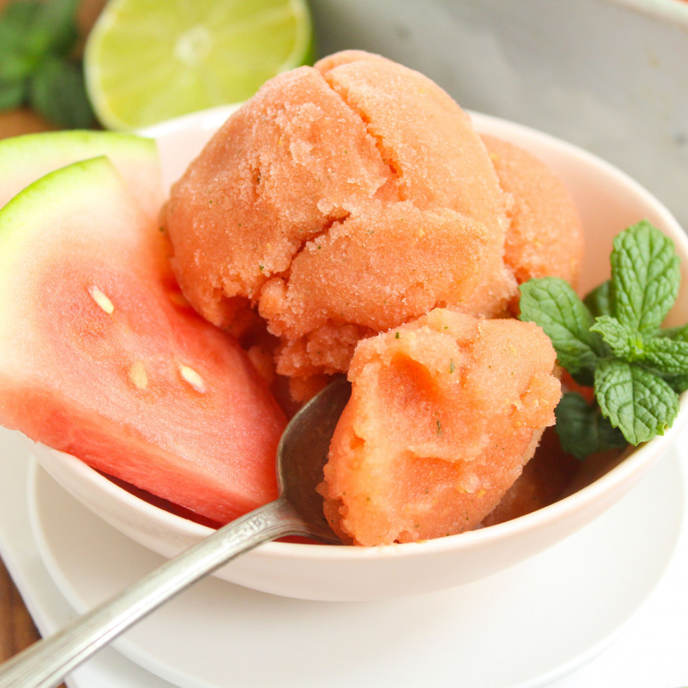 watermelon mojito sorbet in bowl with mint and watermelon wedges