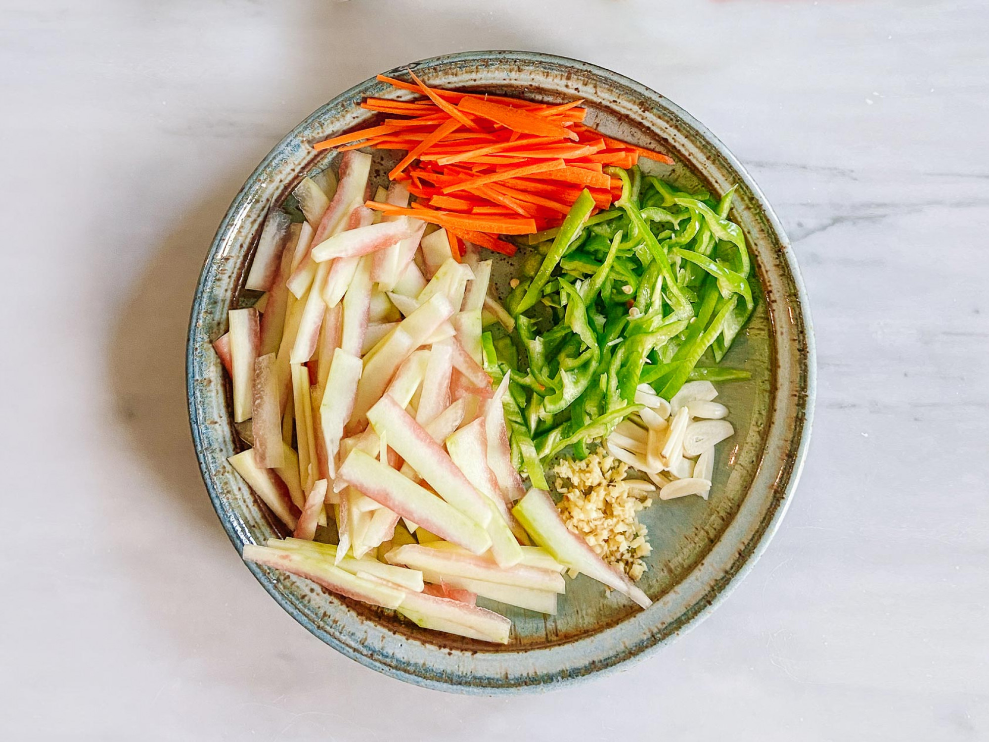 watermelon rind julienned in a bowl with other stir fry ingredients