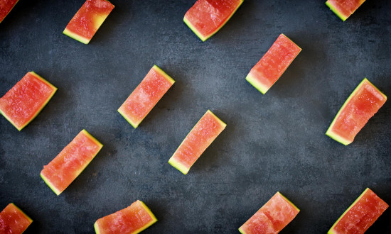 pieces of watermelon rind scattered on dark background
