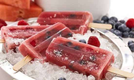 Many watermelon berry popsicles on a tray