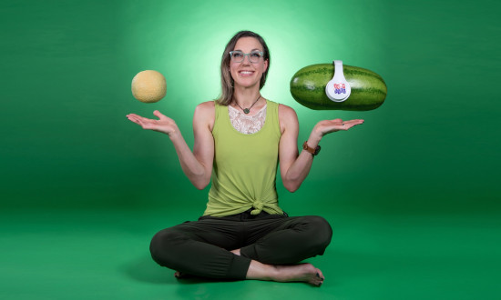 Jill sitting on the floor with legs crossed and melons floating over hands