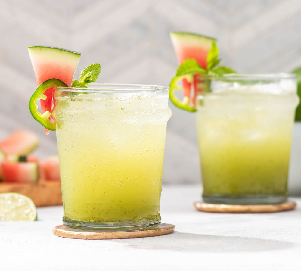 two green cocktails made with watermelon rind, lime and jalapenos
