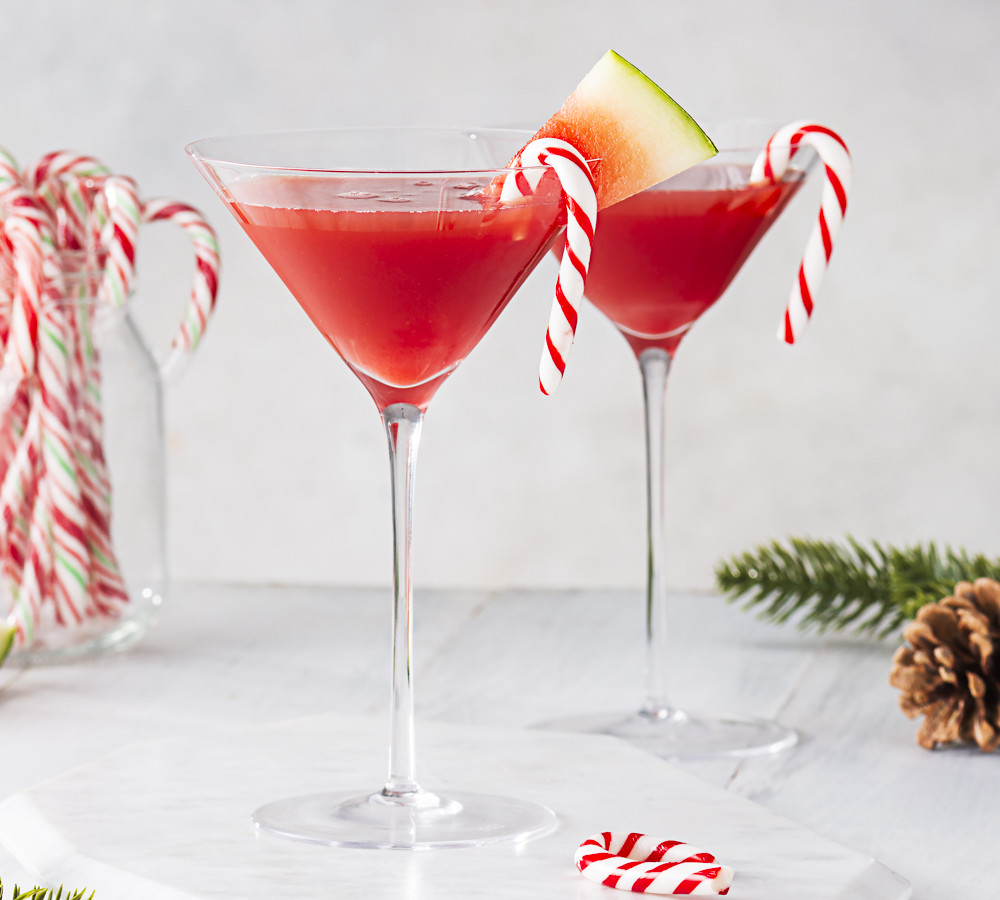Two red cocktails in a martini glasses with candy canes
