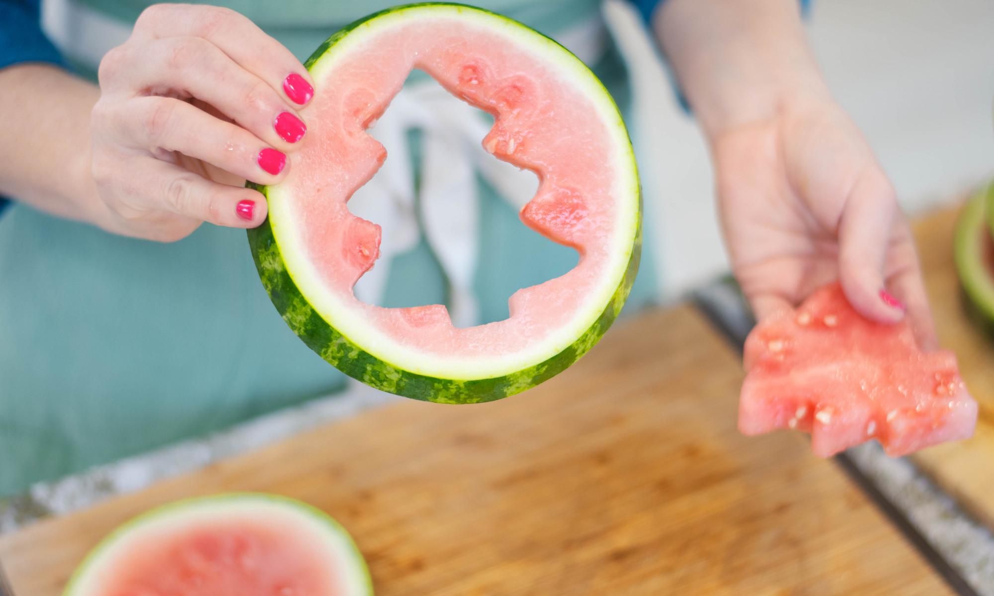 person holding sample of watermelon Christmas tree cutout pieces