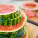 round watermelon slices stacked on cutting board