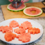 watermelon Christmas tree cutouts on white plate with utensil in background