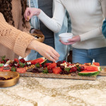 four people participating in making of a watermelon board