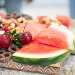 watermelon and other fruit, nuts, chocolate on serving board