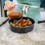 person preparing watermelon glazed meatball on countertop