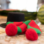 snowman hat and scarf in foreground, in making a "watermelon" snowman, on countertop