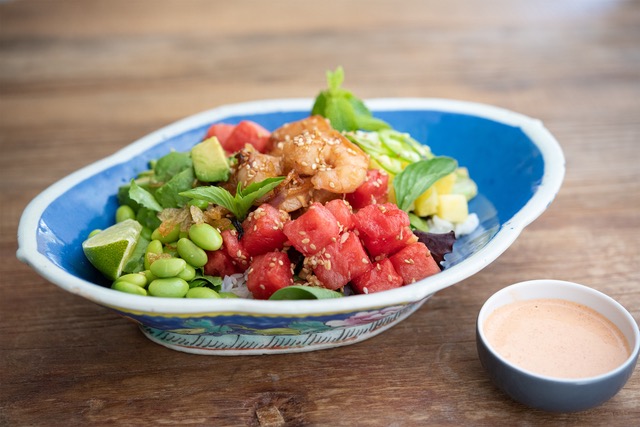 Shrimp and Watermelon Poke Bowl served in blue and white bowl with sauce in side bowl.