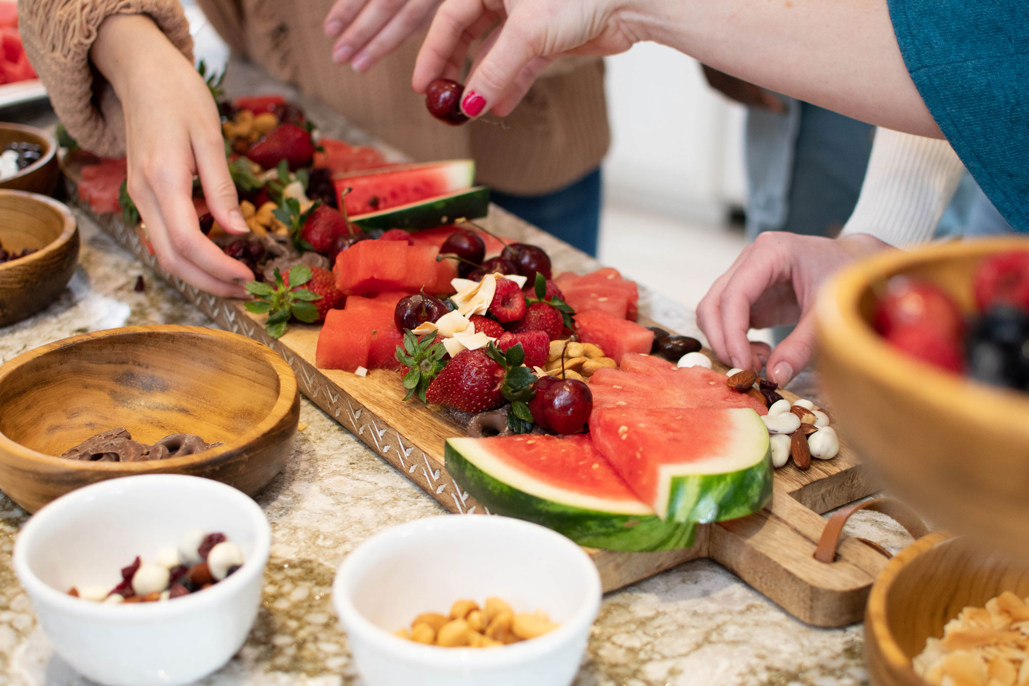 persons arranging charcuterie board