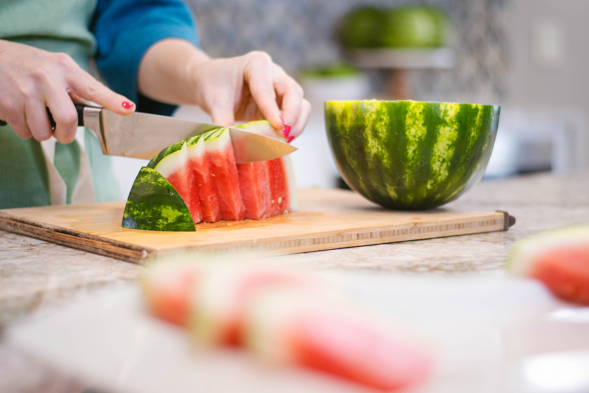 person cutting watermelon wedges