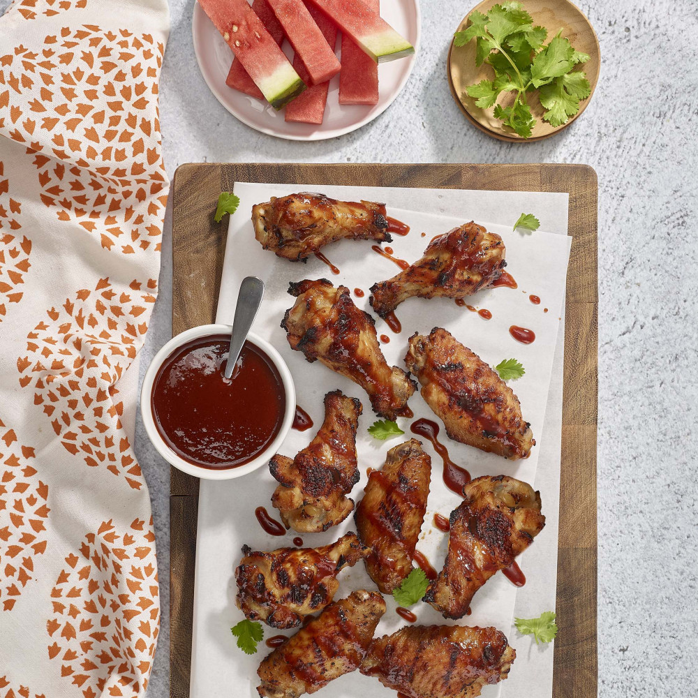 Glazed chicken wings with sauce on a platter.