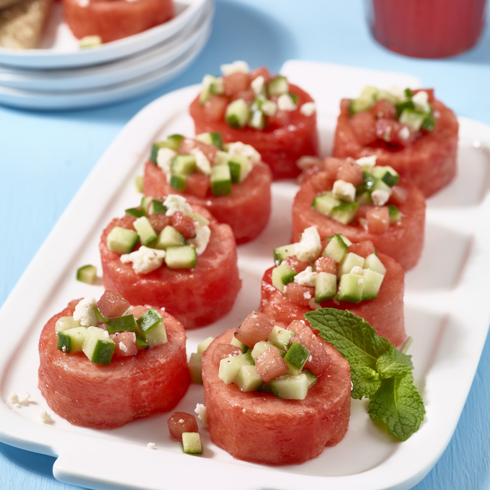 Watermelon cup appetizers with cucumber, mint and feta on serving plate.