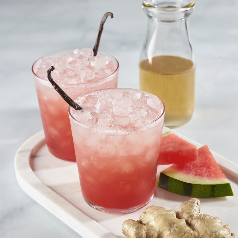 Two watermelon, ginger and vanilla spritz beverages with ice.