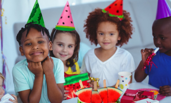 Kids at a watermelon party with watermelon party hats on